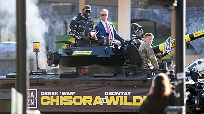 Heavyweight boxer Derek Chisora rides army tank with Nigel Farage to press event