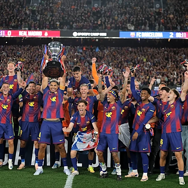 Watched by its grieving coach, Barcelona retains Spanish league title by beating rival Real Madrid
