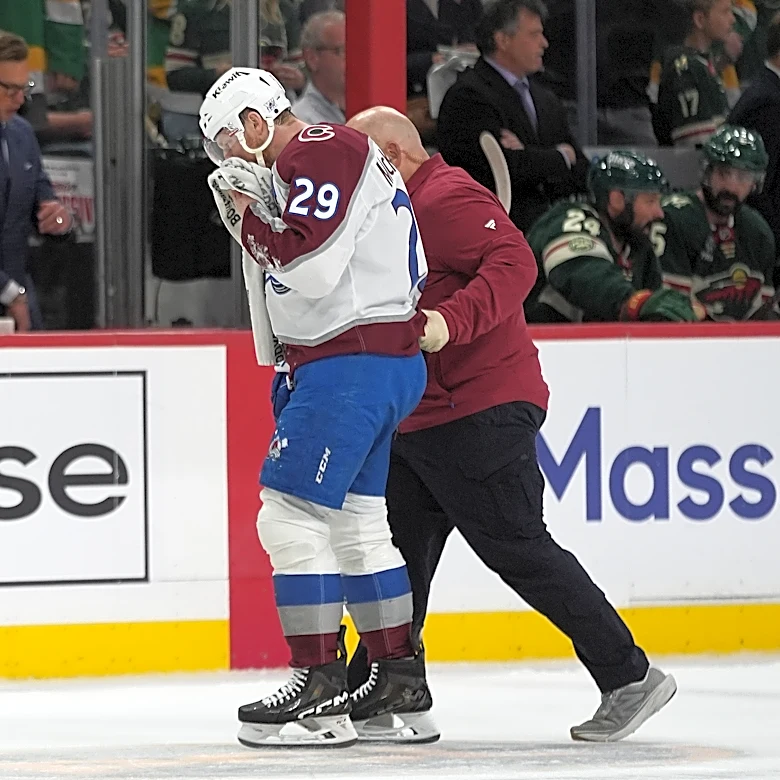 MacKinnon takes a puck from an Avs teammate to the face