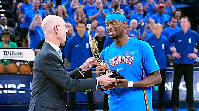 Shai Gilgeous-Alexander gets the MVP trophy from NBA Commissioner Adam Silver