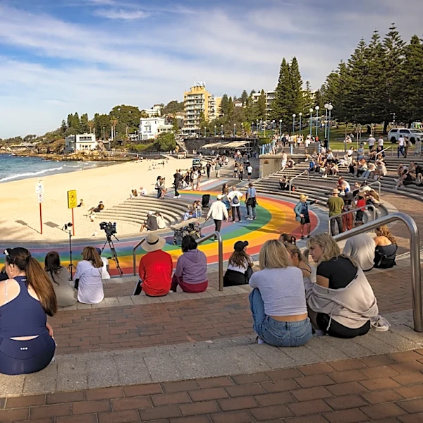 Woman mauled by shark off Sydney beach grabs onto a lifeguard's paddleboard