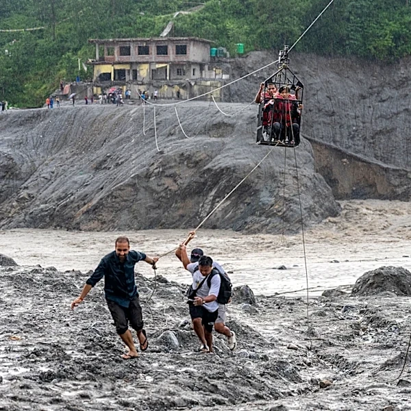 Trading food for medicine and crossing the river by zip line are part of life in Nepal flood zone