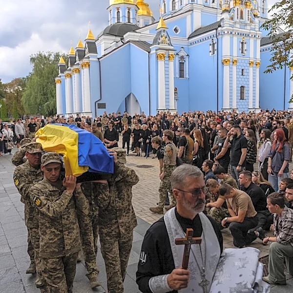 A pregnant soldier mourns her 21-year-old husband at his funeral in Ukraine