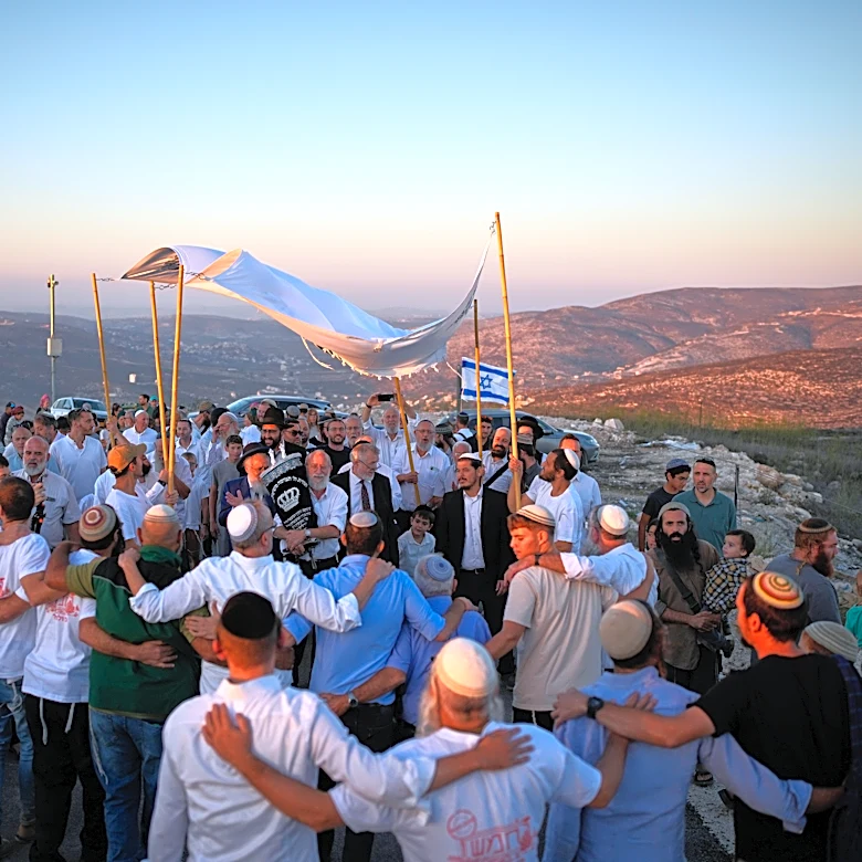 Israeli settlers, some armed, celebrate a new synagogue in the occupied West Bank, in photos