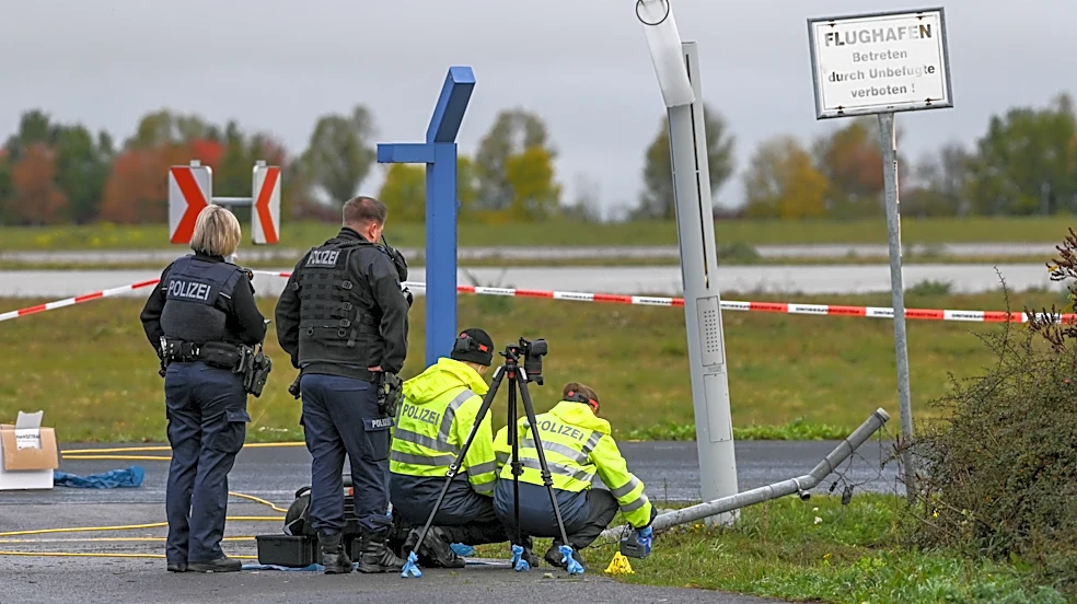 German police say 2 men turned themselves in after smashing their car into an airport fence
