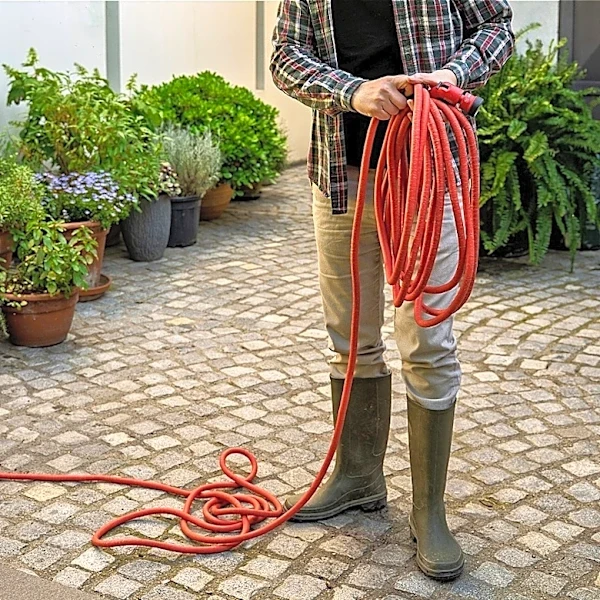 Turn A Wire Hanger Into A DIY Solution That Keeps Garden Hoses Organized