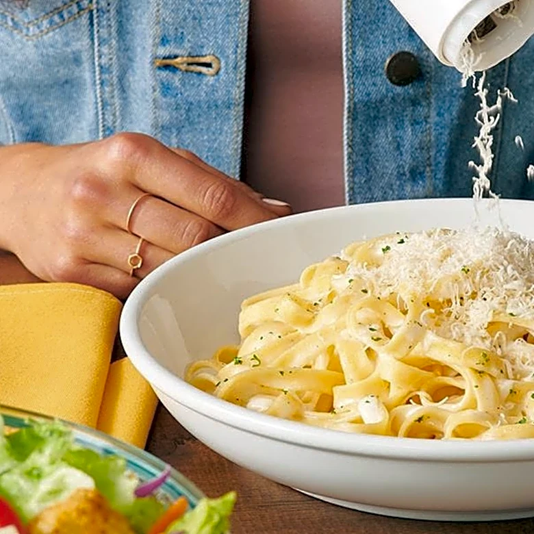 That Freshly Grated Cheese At Olive Garden Isn't What Many Diners Think