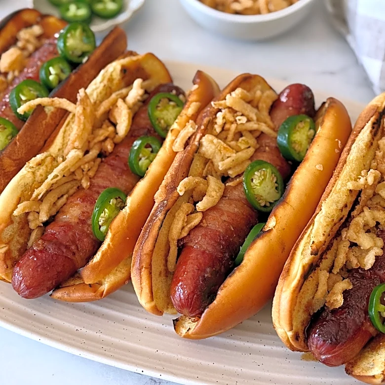 These Bacon-Wrapped Hot Dogs Bring Sweet, Smoky, And Spicy Flavor To The Grill
