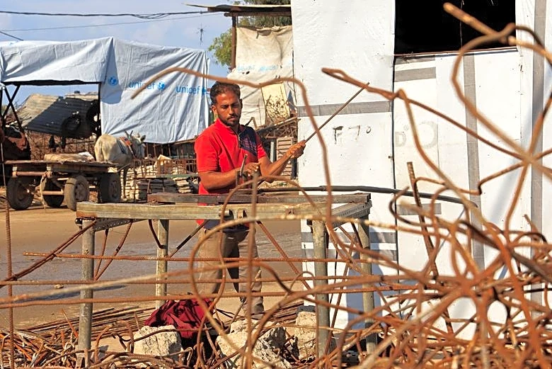 Desperate Gazans pull iron bars from rubble to construct tents and scratch out a living