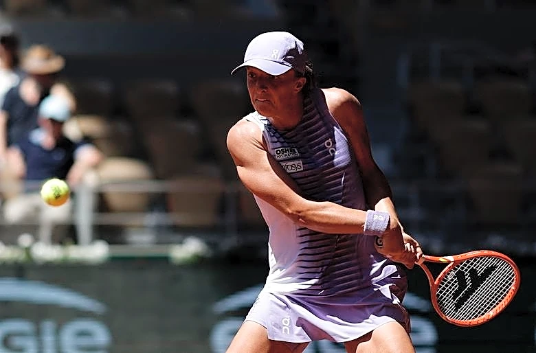 Tennis-Erratic Swiatek reaches French Open round three