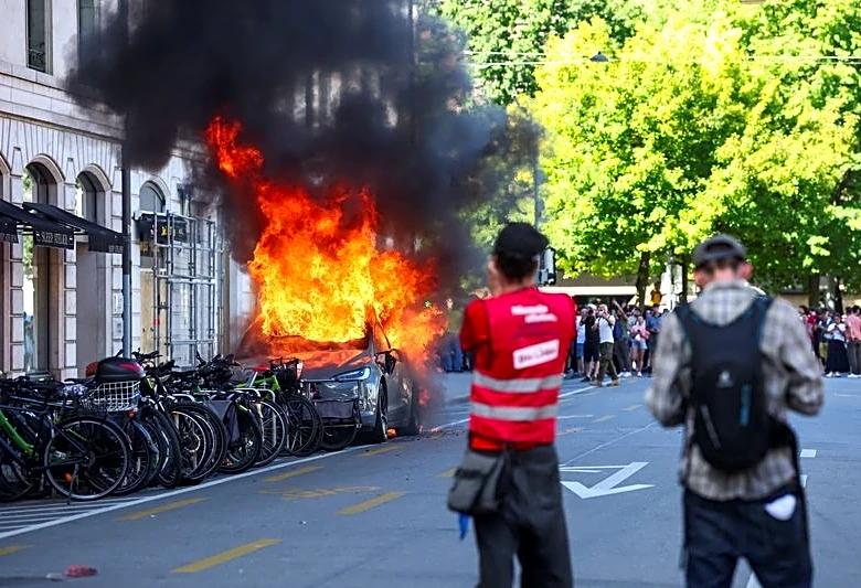 Protesters smash windows and set Tesla ablaze in anti-G7 march in Geneva