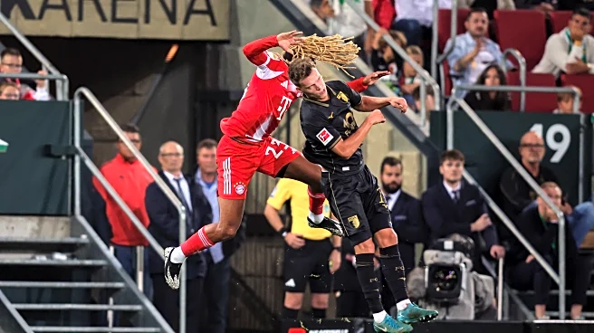 Sacha Boey apologizes to FC Augsburg’s Robin Fellhauer following Bayern Munich win