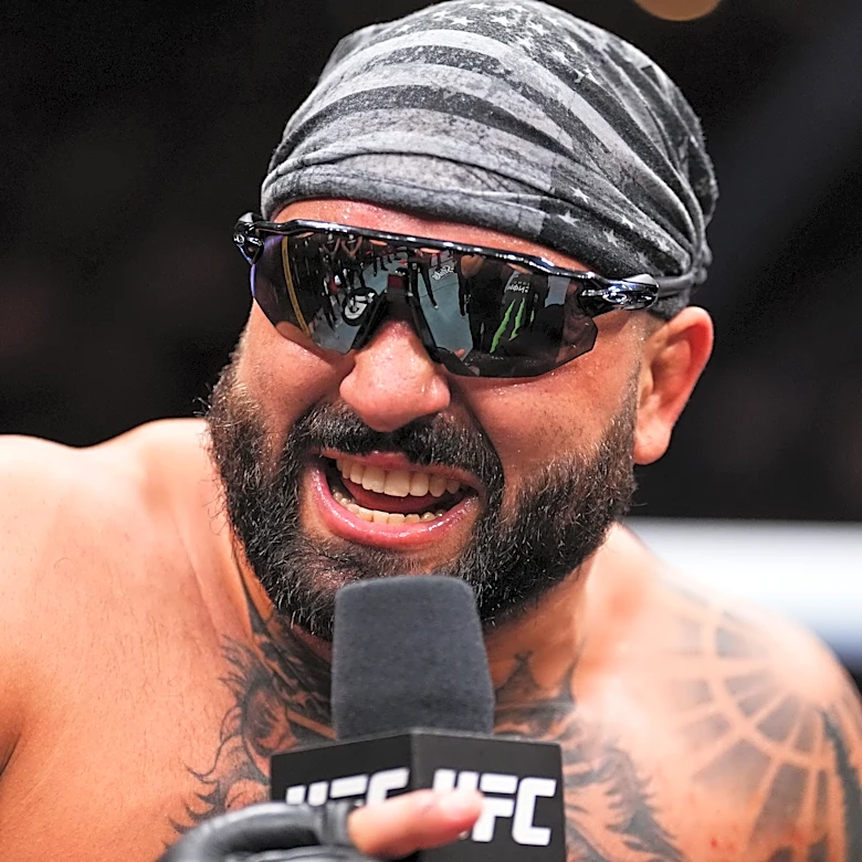 Video: Village idiot sneaks into UFC 327 media day, threatens to ‘cut up’ confused Jiri with plastic sword