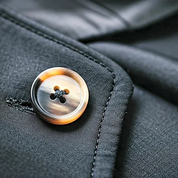 How Hand-Finished Edges, Horn Buttons, and Lining Choices Signal Luxury