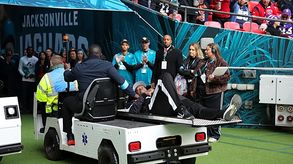 Official carted off with leg injury after falling on slippery London field