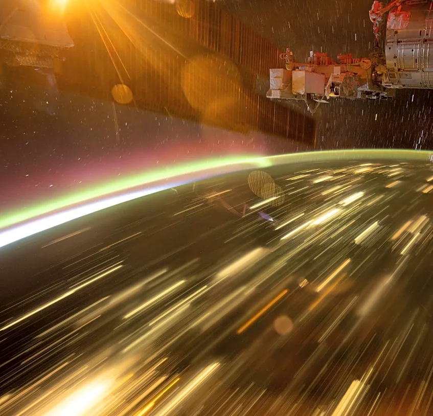 NASA astronaut captures auroras streaking over city lights from ISS
