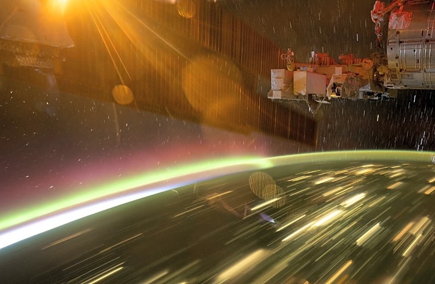 NASA astronaut captures auroras streaking over city lights from ISS